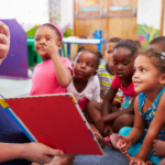 Group of children looking at teacher holding a picture book