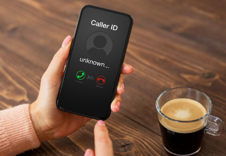 Smartphone with unknown caller on screen, understanding robocalls