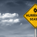 Grey clouds behind a yellow sign with a hurricane symbol and the words "hurricane season"