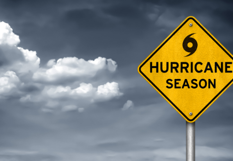 Grey clouds behind a yellow sign with a hurricane symbol and the words "hurricane season"