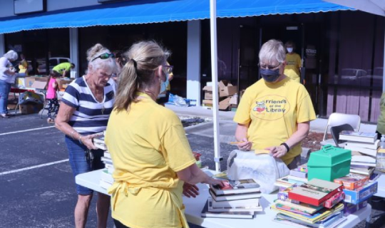 FOCCLS President Sandy Price and Vice President Janet add up a sale at a sidewalk sale