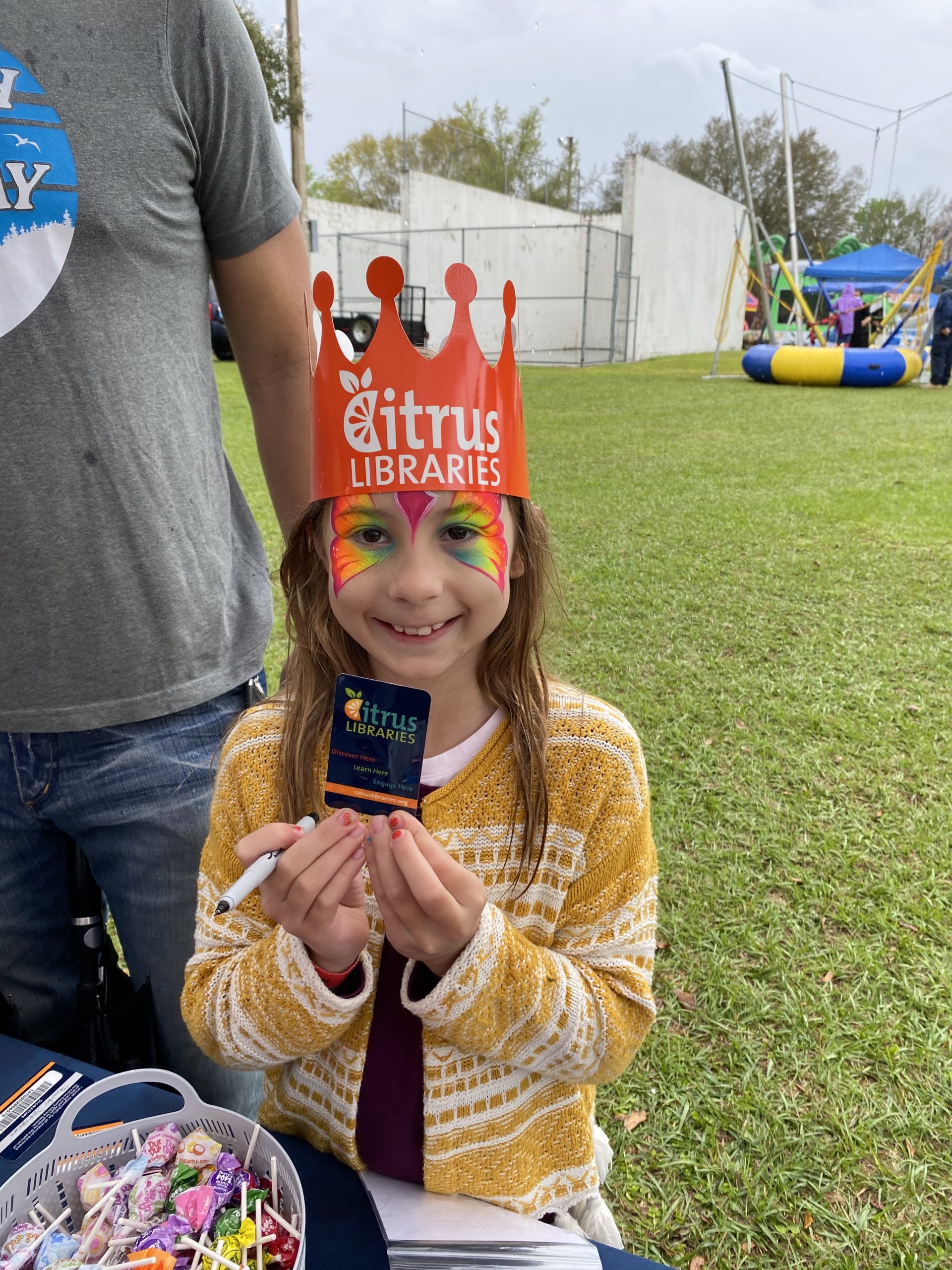 Child holding new Library card at the Floral City Strawberry Festival
