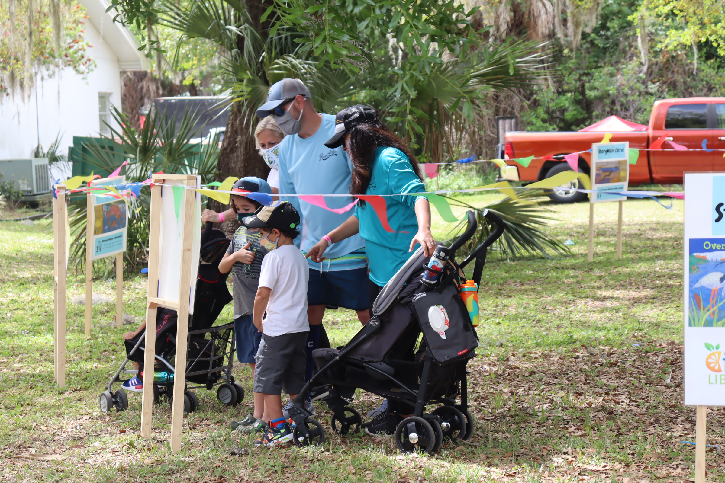 Family vewing the Storywalk at the Floral City Strawberry Festival