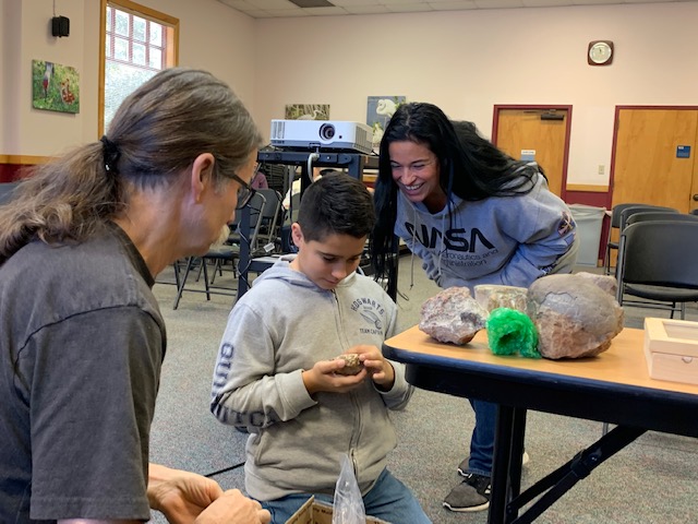 Group looking at fossils at the Lakes Region Library