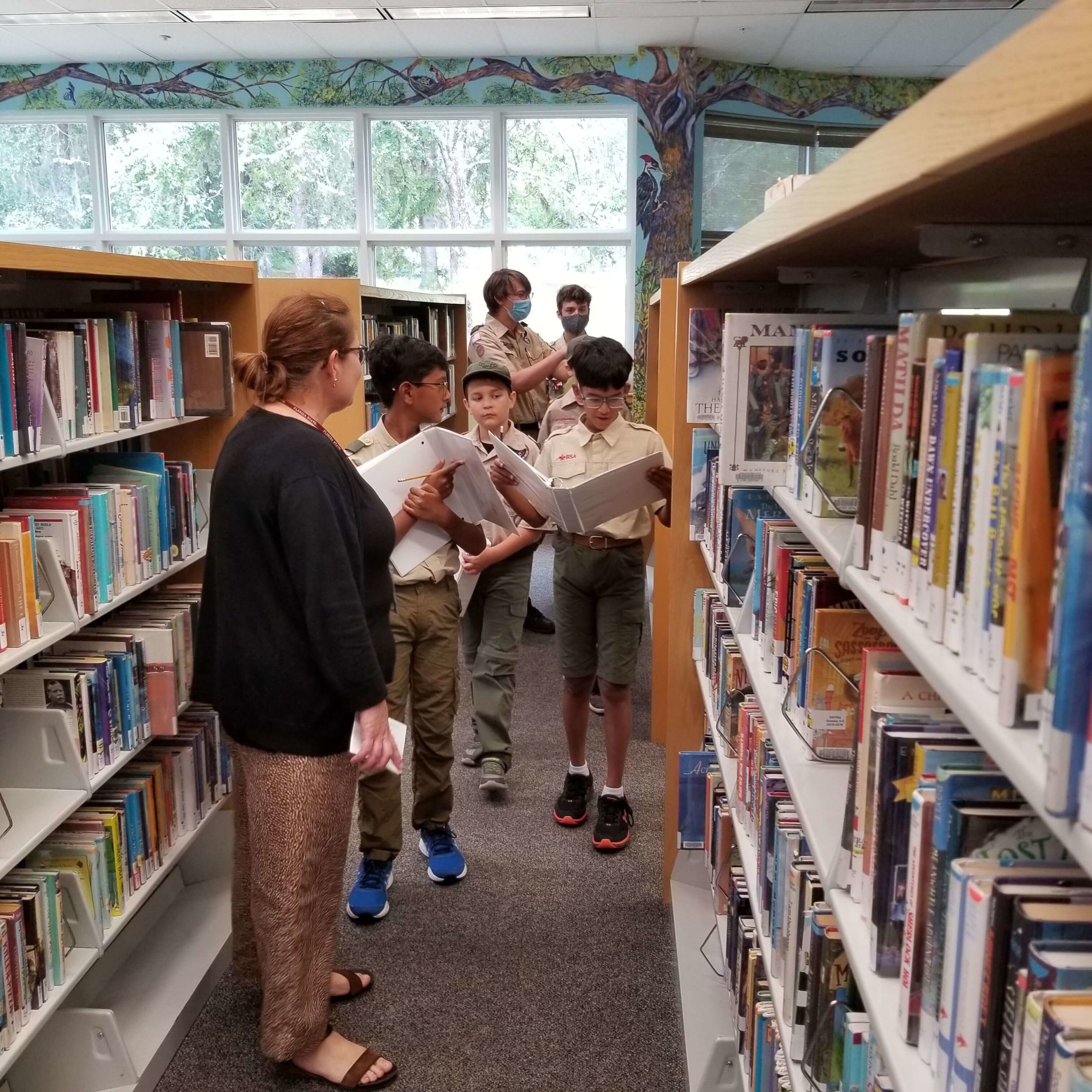 Boy Scout Troop 452 explore the youth room with library staff