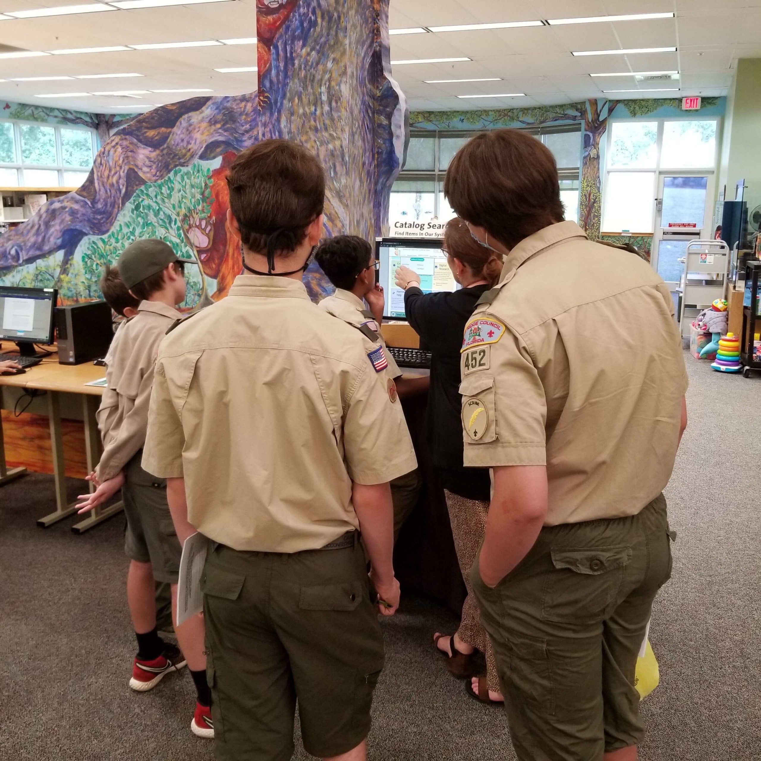 Boy Scout Troop 452 learning from library staff on navigating the library website.