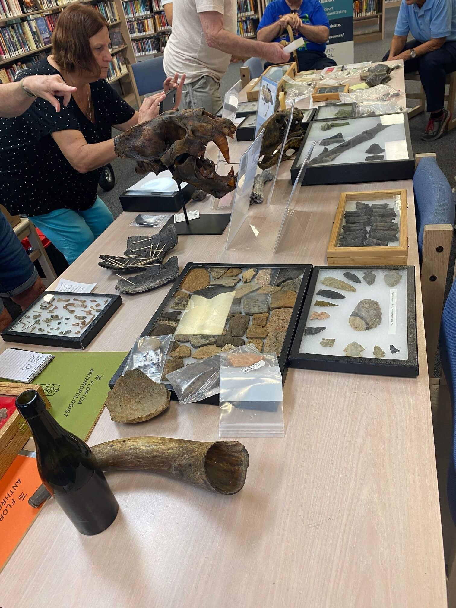 SETS Foundation members work together on the layout of the items that will be included in the new permanent display cases at the Lakes Region Library