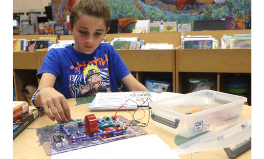 Fifth grader Atticus Herrero worked through a roadblock with the snap circuit board included in the “Electricity” themed STEM Discovery Kit.”