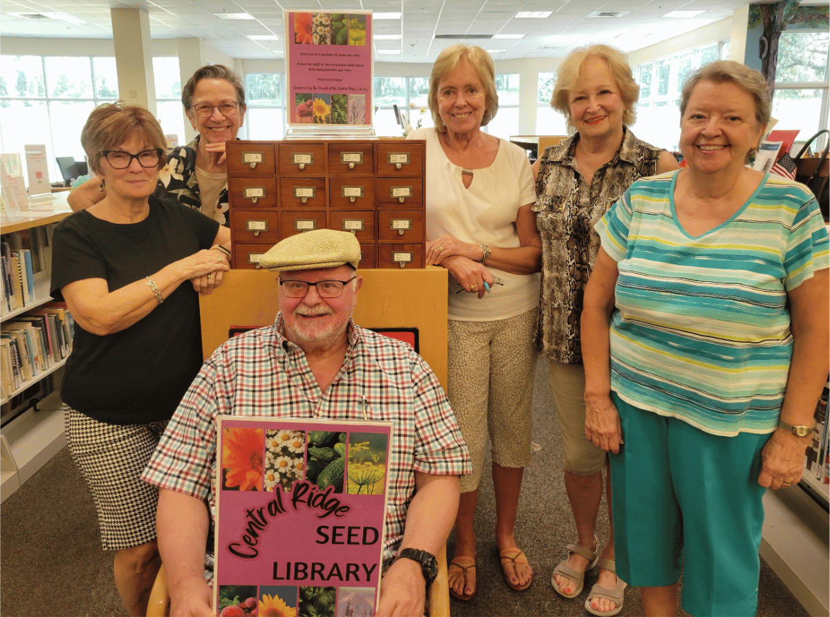 The Friends of the Central Ridge Library surround the new Seed Library for the Central Ridge branch in Beverly Hills after their September meeting.